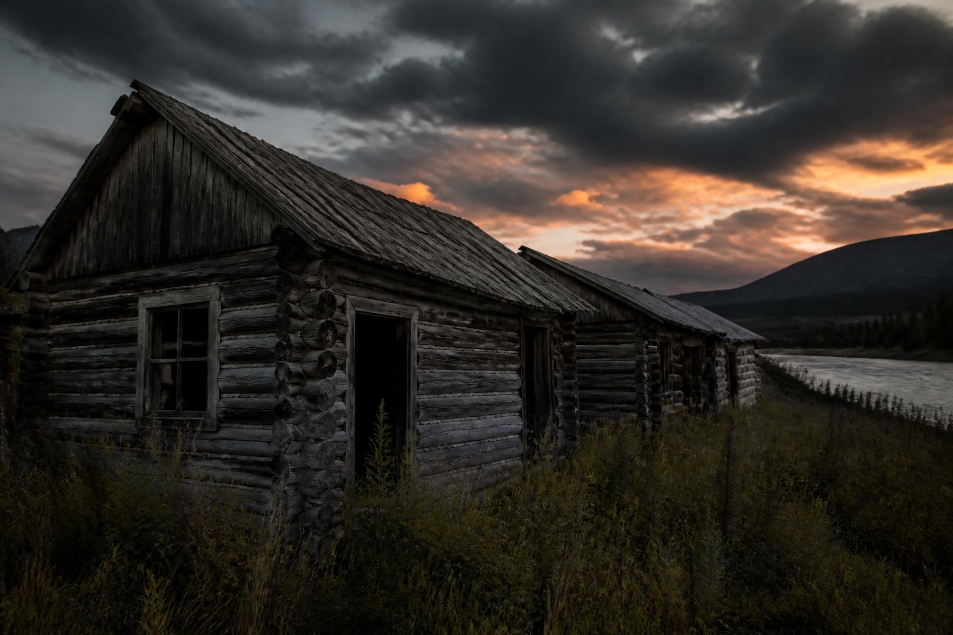 Abandoned gold rush log cabins on the riverbank